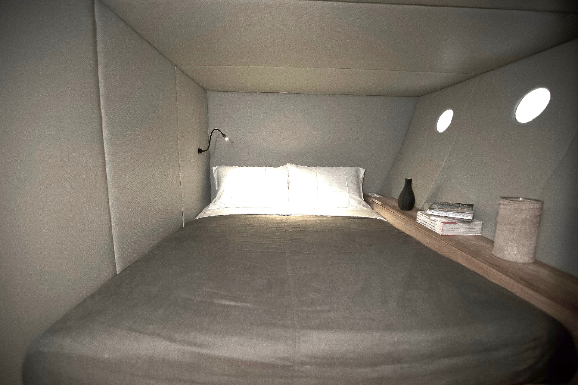 Splendour cocoon cabin with double bed, reading light, portholes and bedside shelf with books