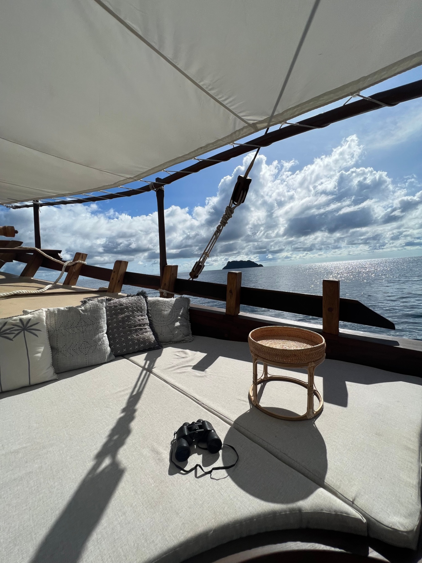Dewata foredeck daybed with binoculars and open sea view at anchor