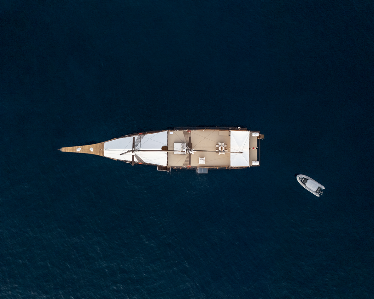 Top-down aerial of Sanya showing the full deck layout with tender beside the yacht